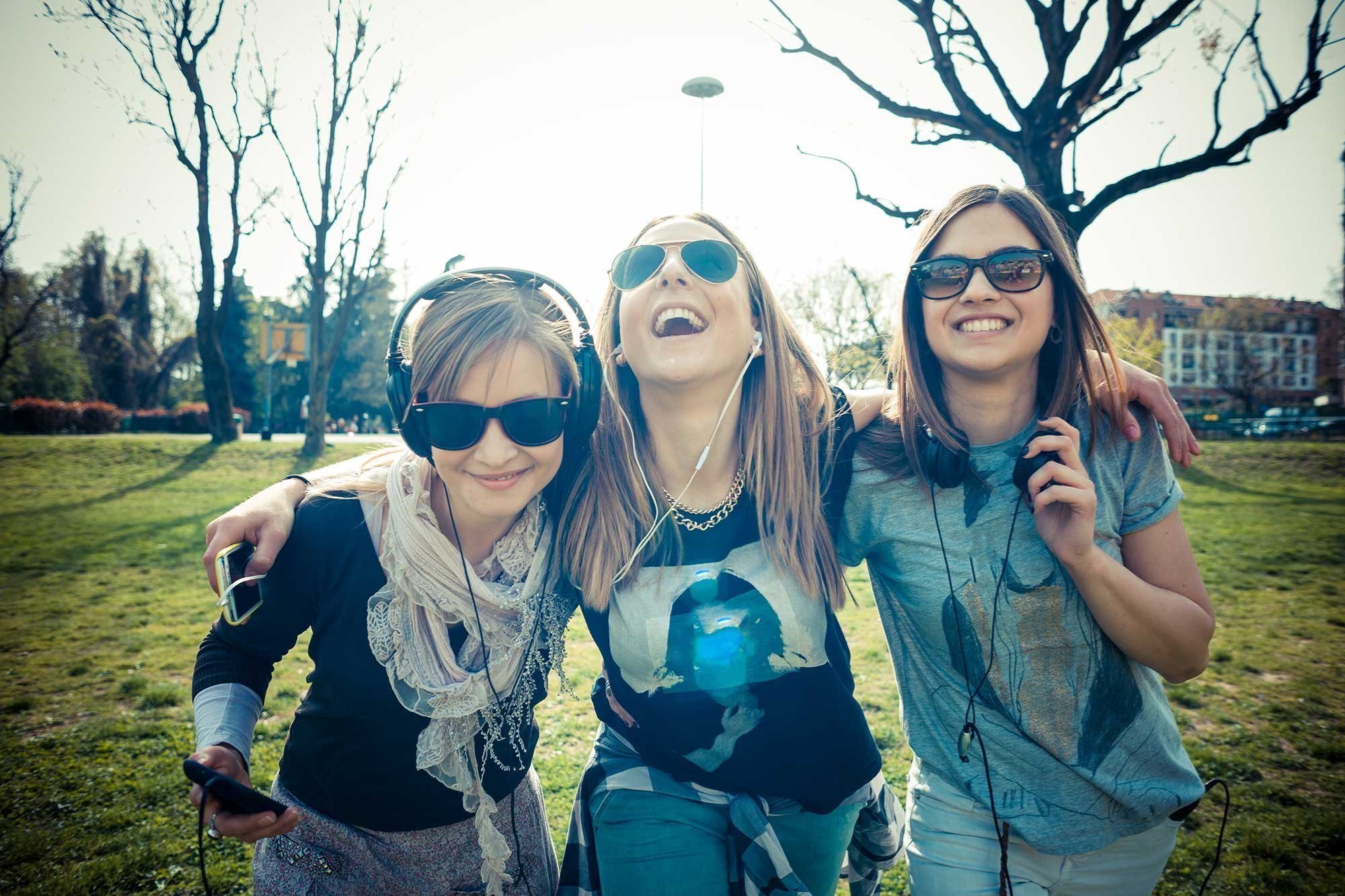 Smilende teenagere i park. Solen skinner.