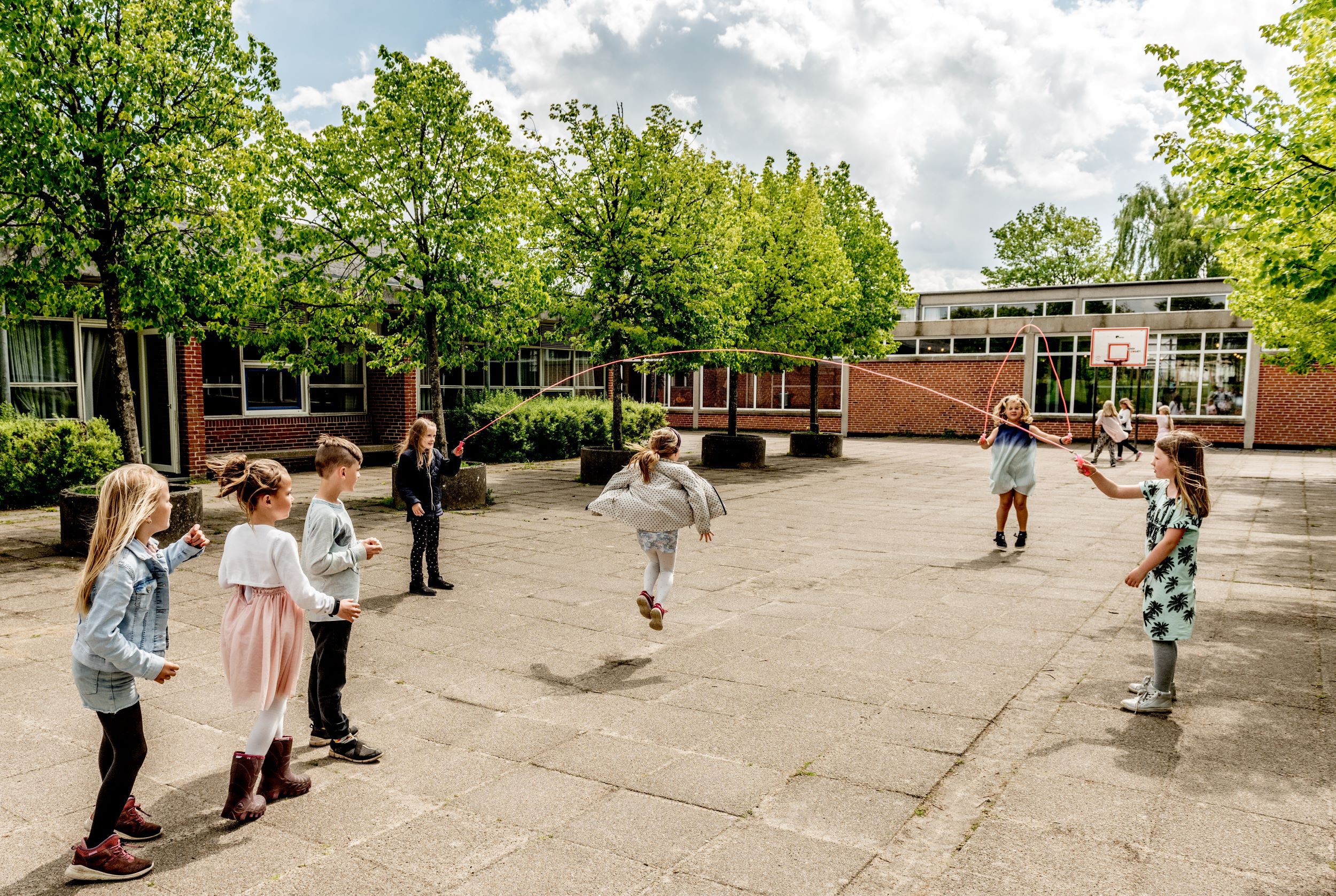 Børn sjipper i skolegård