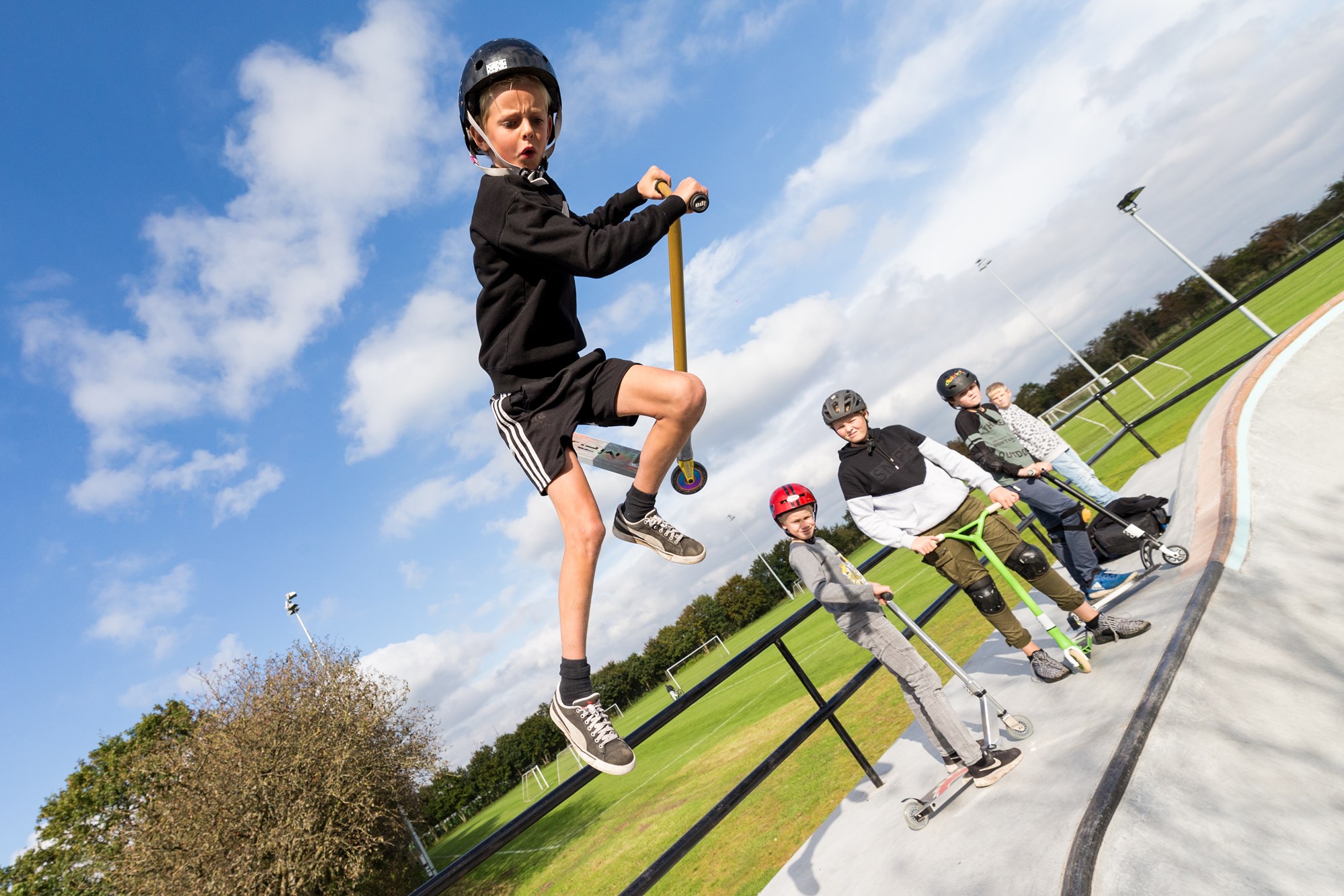 Dreng kører løbehjul på skateboard-bane